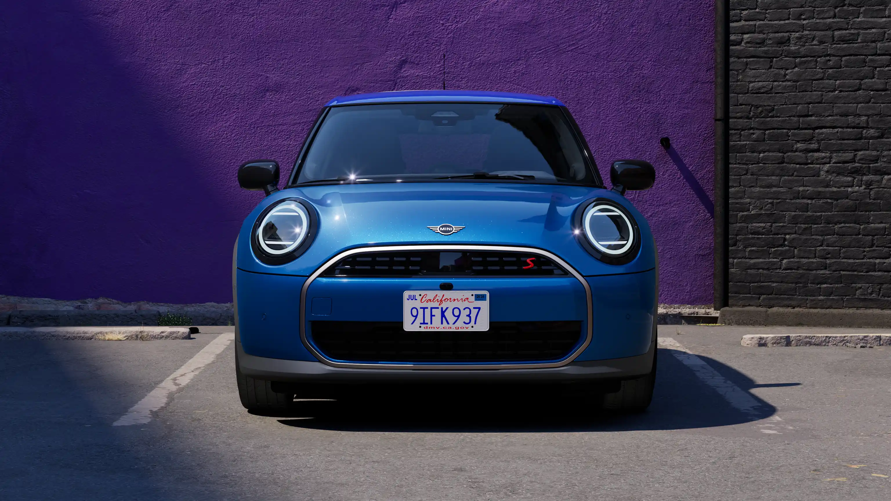 Front view of the new MINI Cooper 5-Door in motion, showing the round front lights and aerodynamically optimised grill.